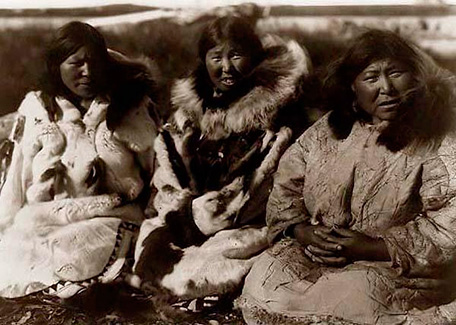 Three Inuit women in the past. White and brown photo.