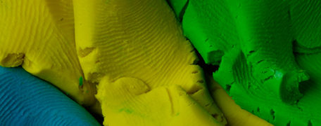 Plasticine in blue, yellow and green colors with fingerprints.